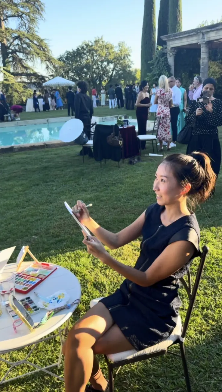 Charlotte GUO dessinant un invité en direct dans les jardins du Château de Sannes, pendant le cocktail