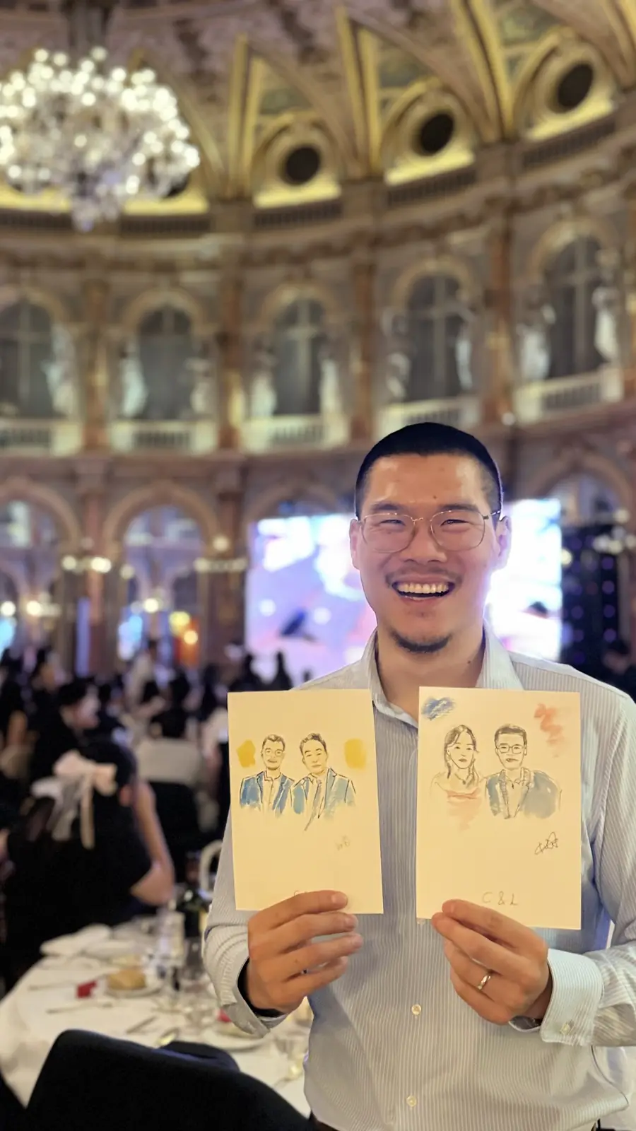 Guest holding two watercolour portraits beneath the dome