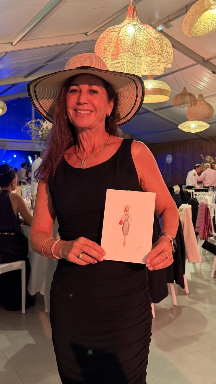 Invitée au chapeau tenant sa silhouette de mode dessinée sur place